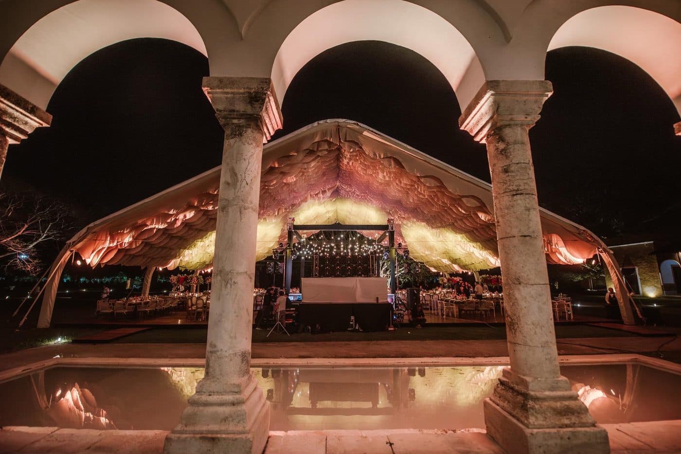 La arcada y la alberca iluminadas durante la fiesta