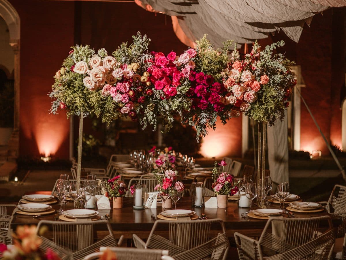 Centro floral sobre la mesa larga de la cena